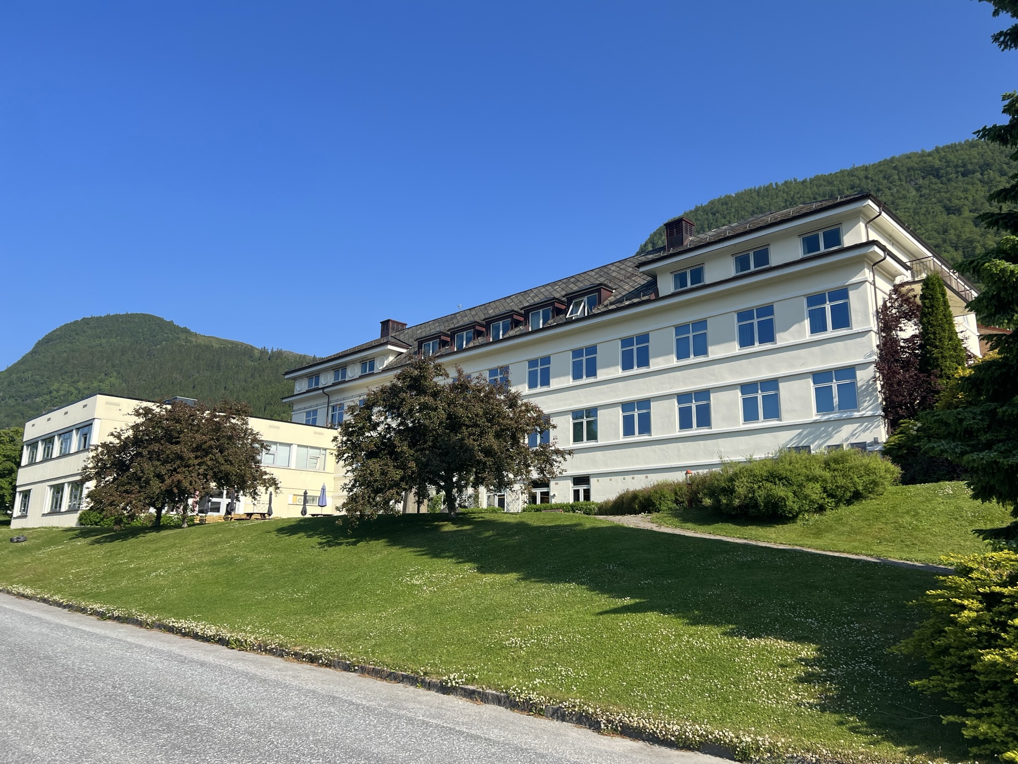 En stor sykehusbygning med en plen foran seg