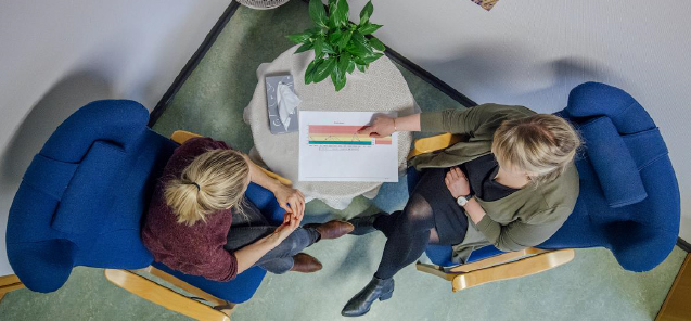 To kvinner som sit i kvar sin stol rundt eit bord, sett ovanfrå i fugleperspektiv