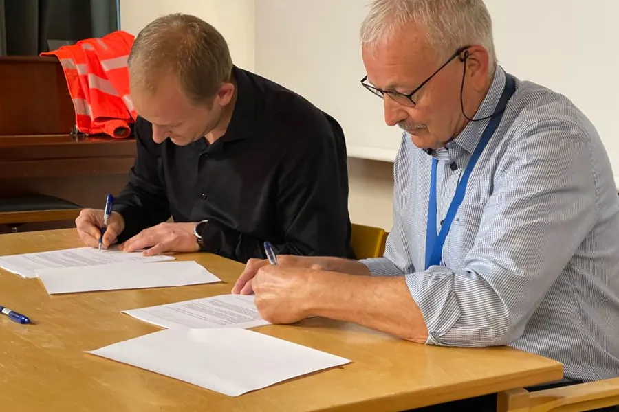 En mann som skriver på et stykke papir