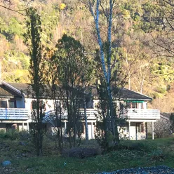 Kvite rekkehus med skog i bakgrunnen